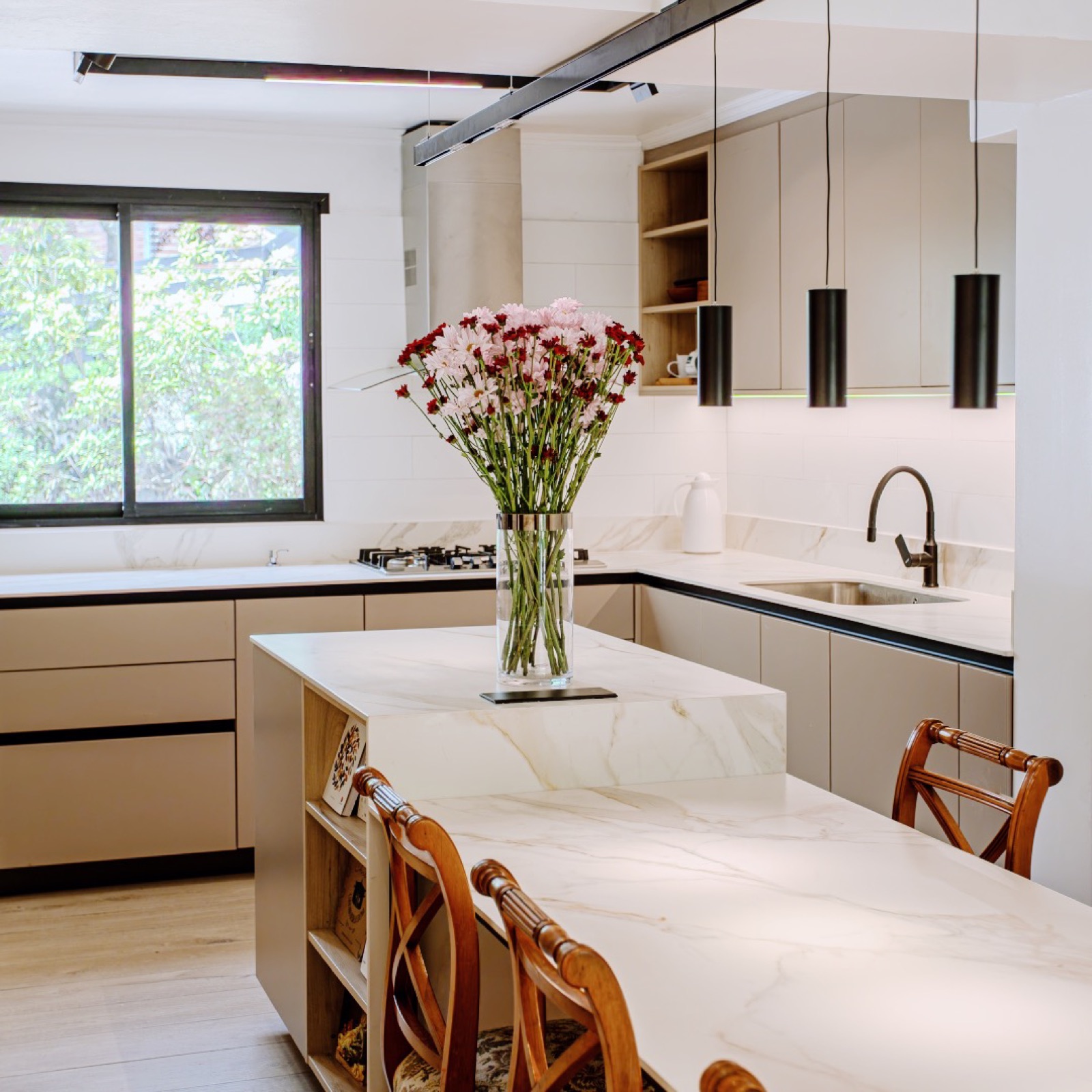Cocina EstudioLK con isla y muebles a medida en tonos claros.